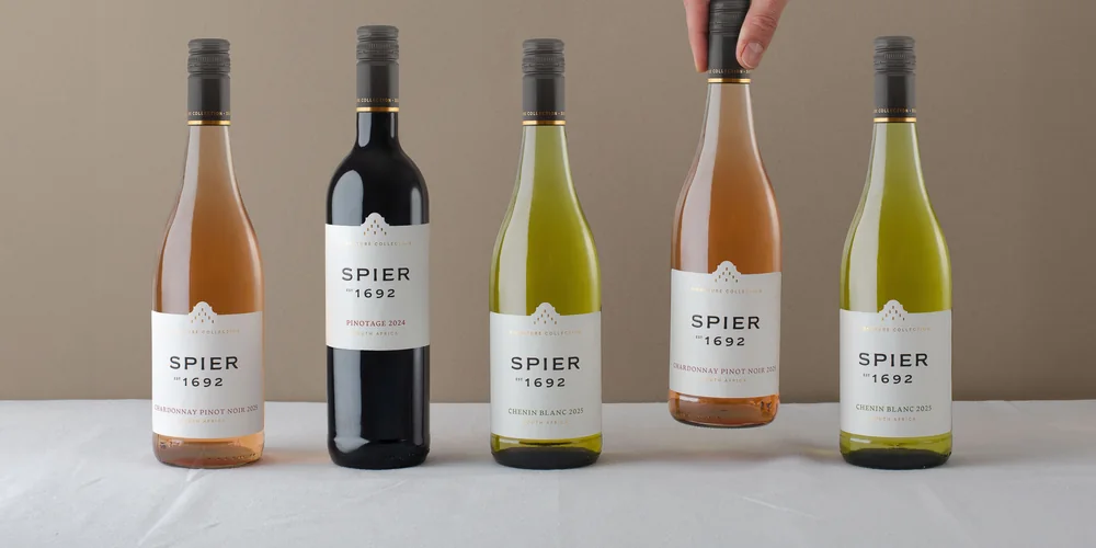 Five bottles of Spier Signature in a row on a white tablecloth
